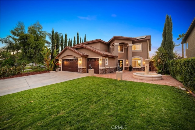 mediterranean / spanish-style house with a yard and a garage