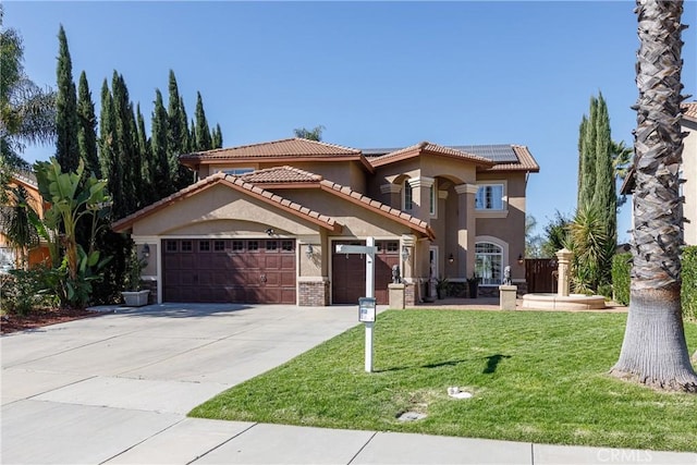 mediterranean / spanish home featuring a front lawn, a garage, and solar panels