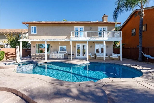 rear view of property with area for grilling, french doors, a balcony, and a patio