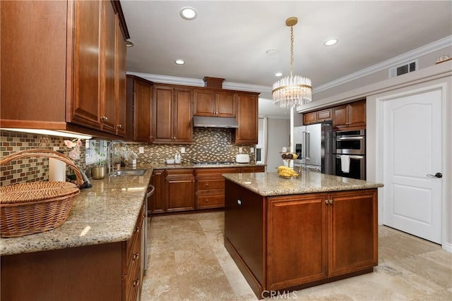 kitchen with pendant lighting, a kitchen island, appliances with stainless steel finishes, ornamental molding, and light stone counters