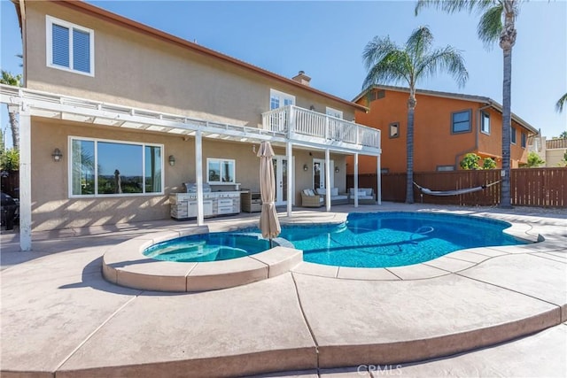 view of pool featuring an outdoor kitchen, a patio, and an in ground hot tub