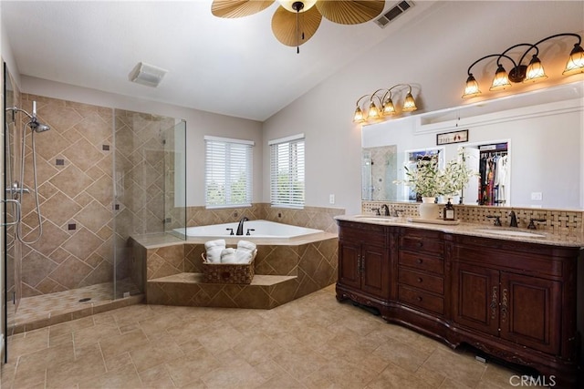 bathroom with ceiling fan, decorative backsplash, plus walk in shower, vaulted ceiling, and vanity