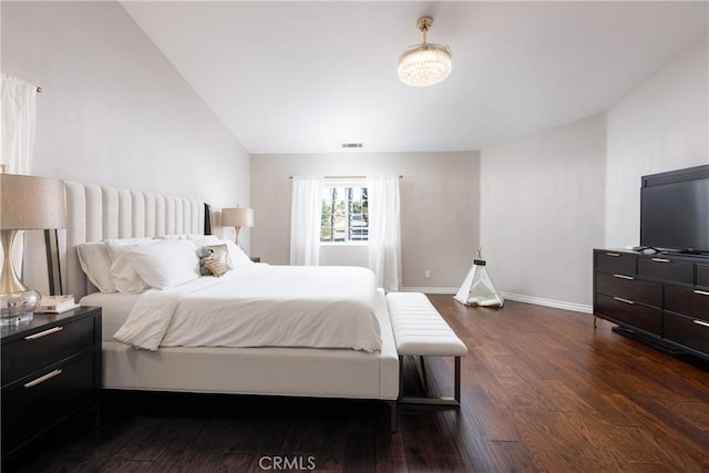 bedroom with dark hardwood / wood-style floors and lofted ceiling