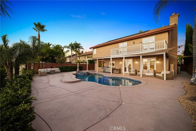 pool at dusk featuring an outdoor hangout area and a patio area