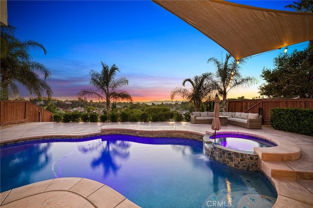 pool at dusk featuring an outdoor living space, a patio, and an in ground hot tub