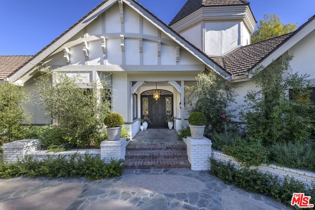 property entrance with covered porch and a balcony