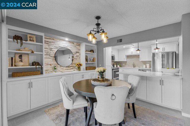 dining space featuring a textured ceiling and built in features