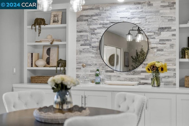 interior details featuring vanity, built in features, and backsplash