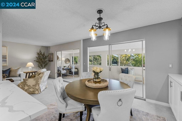 dining area with a textured ceiling and a notable chandelier