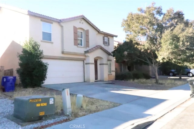 mediterranean / spanish-style home with a garage, a tiled roof, concrete driveway, and stucco siding