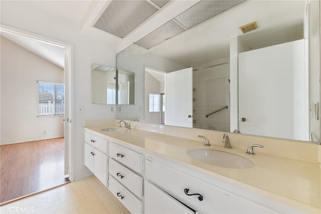 bathroom featuring hardwood / wood-style floors, vanity, and vaulted ceiling