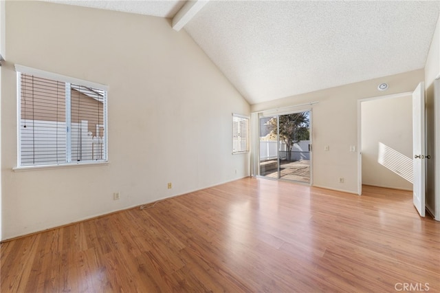 interior space featuring vaulted ceiling with beams, a textured ceiling, and light hardwood / wood-style flooring