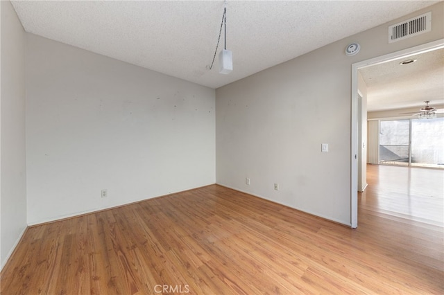 spare room featuring a textured ceiling, light hardwood / wood-style floors, and ceiling fan