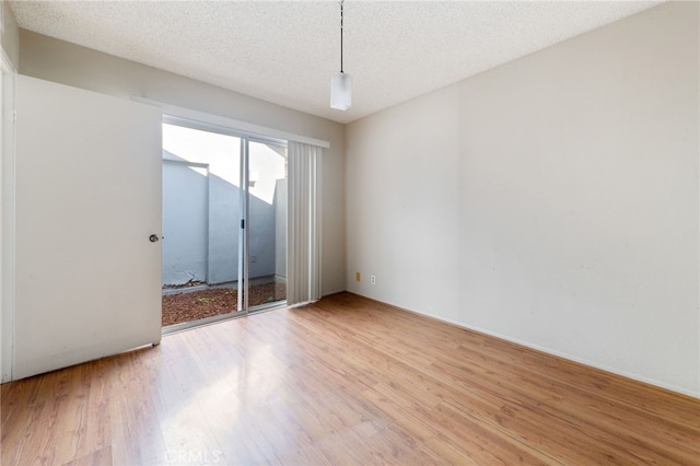 empty room with hardwood / wood-style floors and a textured ceiling