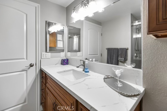 bathroom with a shower with door and vanity