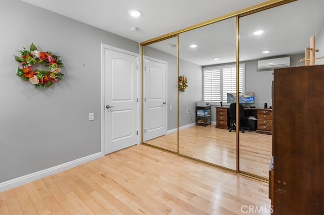 office with hardwood / wood-style flooring and an AC wall unit