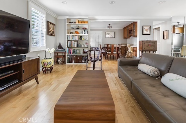 living room with light wood-type flooring and crown molding