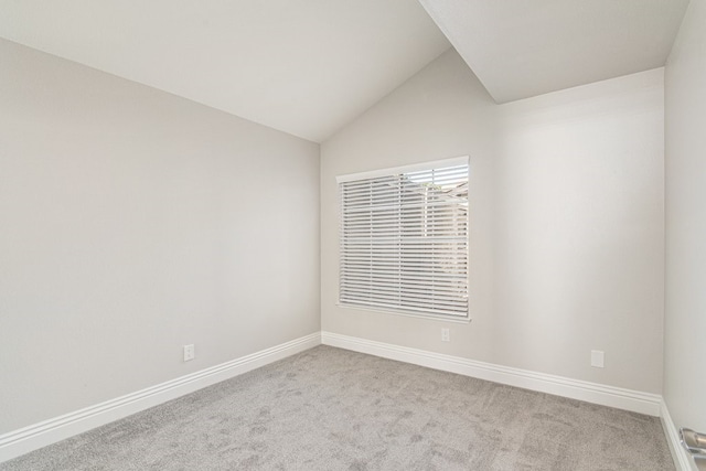 unfurnished room featuring light carpet and vaulted ceiling