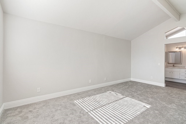 interior space featuring carpet, lofted ceiling with beams, sink, and ensuite bathroom