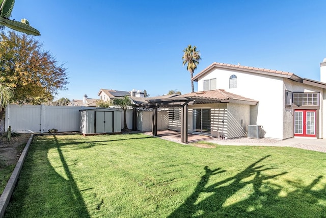 rear view of property with central AC unit, a shed, a pergola, and a lawn