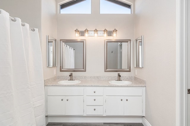 bathroom featuring vanity, a wealth of natural light, and lofted ceiling