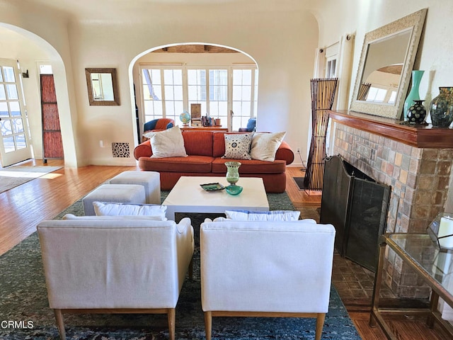 living room featuring dark wood-type flooring and a tile fireplace