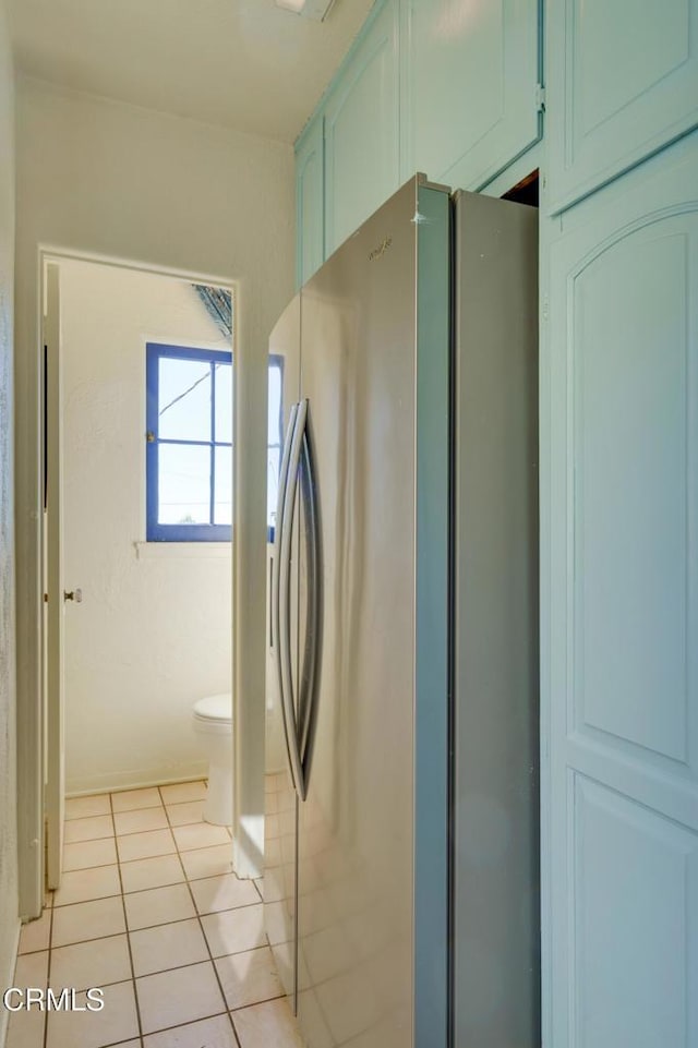 kitchen featuring light tile patterned flooring and stainless steel fridge