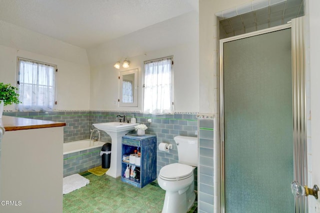 bathroom featuring tile walls, plenty of natural light, plus walk in shower, and toilet