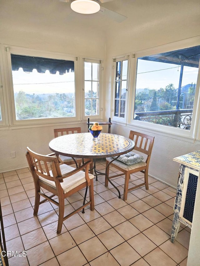 dining space with ceiling fan and light tile patterned flooring