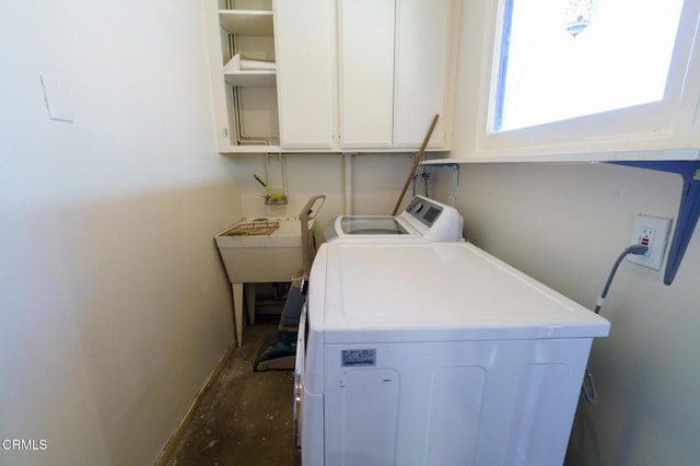 laundry area with cabinets, independent washer and dryer, and sink