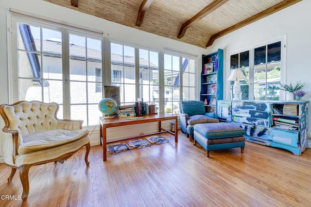 sitting room featuring beamed ceiling, brick ceiling, and light wood-type flooring