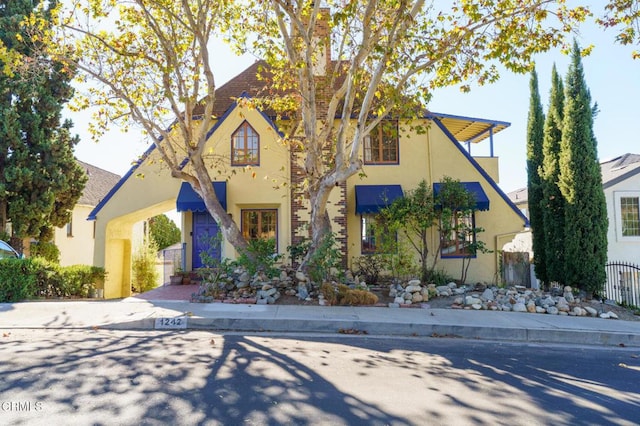 view of front of home featuring stucco siding and fence