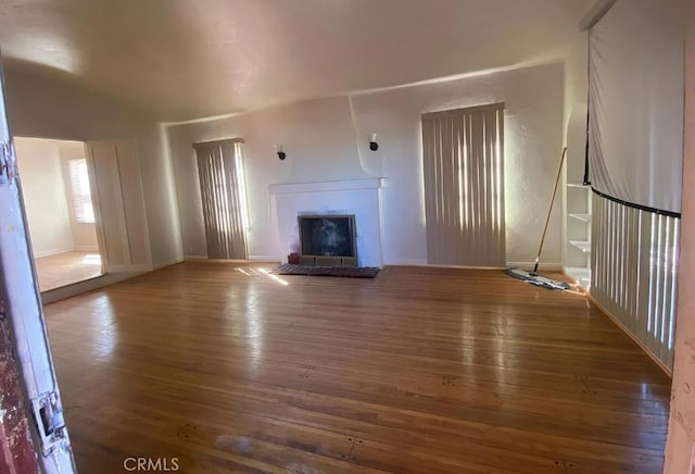 unfurnished living room with dark hardwood / wood-style flooring and a fireplace