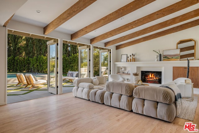 living room featuring vaulted ceiling with beams and light wood-type flooring