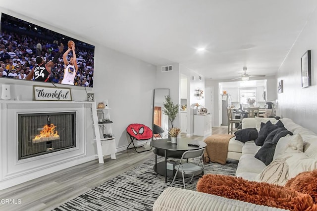 living room with hardwood / wood-style floors and ceiling fan