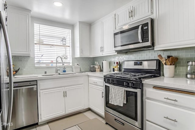 kitchen with stainless steel appliances, white cabinetry, and sink