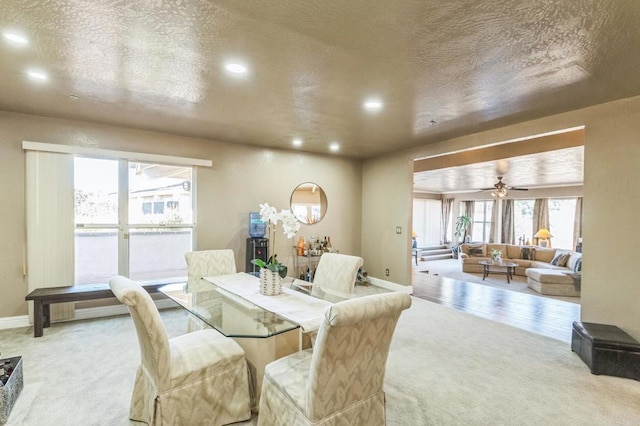 carpeted dining room featuring ceiling fan and a textured ceiling