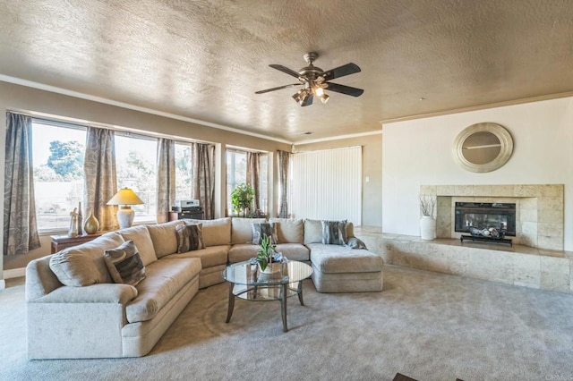 living room featuring carpet flooring, a textured ceiling, ceiling fan, and crown molding