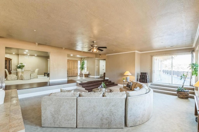 living room with carpet flooring, ceiling fan, crown molding, and a textured ceiling