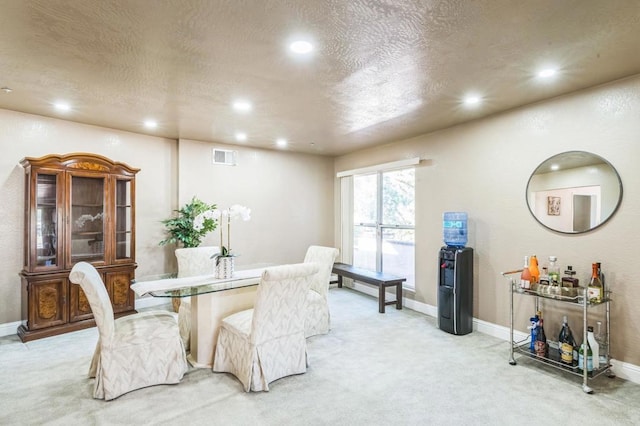 carpeted dining area featuring a textured ceiling