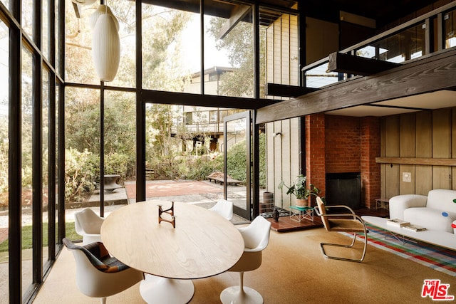 sunroom featuring plenty of natural light and a brick fireplace