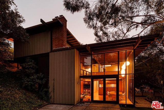 back house at dusk featuring a balcony