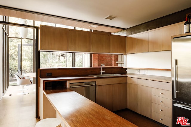 kitchen featuring appliances with stainless steel finishes, butcher block counters, and sink