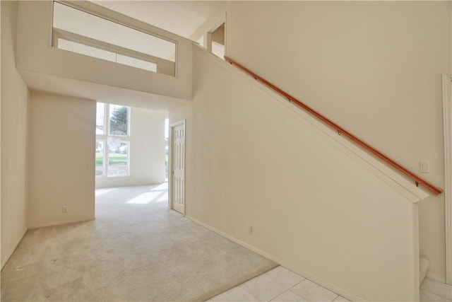 stairway with carpet and a towering ceiling