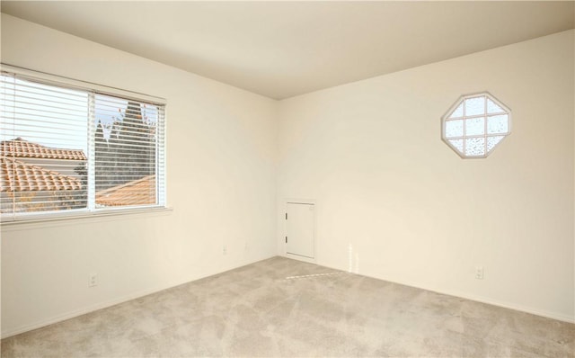 unfurnished room featuring light colored carpet and a healthy amount of sunlight