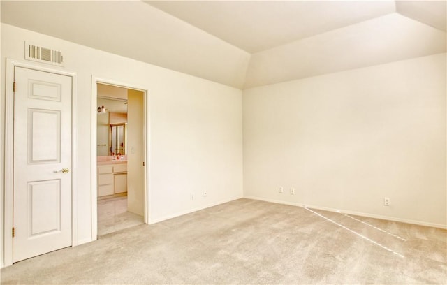 carpeted spare room with vaulted ceiling