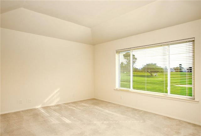 carpeted spare room featuring lofted ceiling