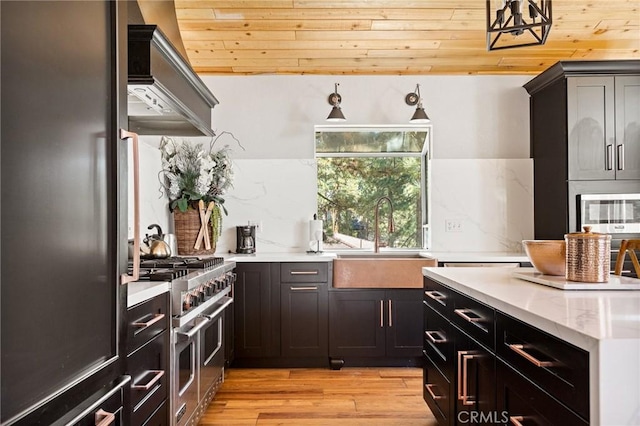 kitchen with wooden ceiling, sink, light hardwood / wood-style flooring, wall chimney exhaust hood, and appliances with stainless steel finishes