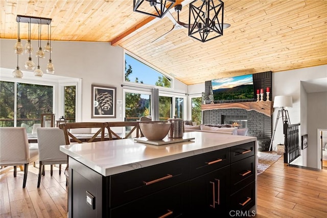 kitchen featuring beamed ceiling, a healthy amount of sunlight, and light hardwood / wood-style floors