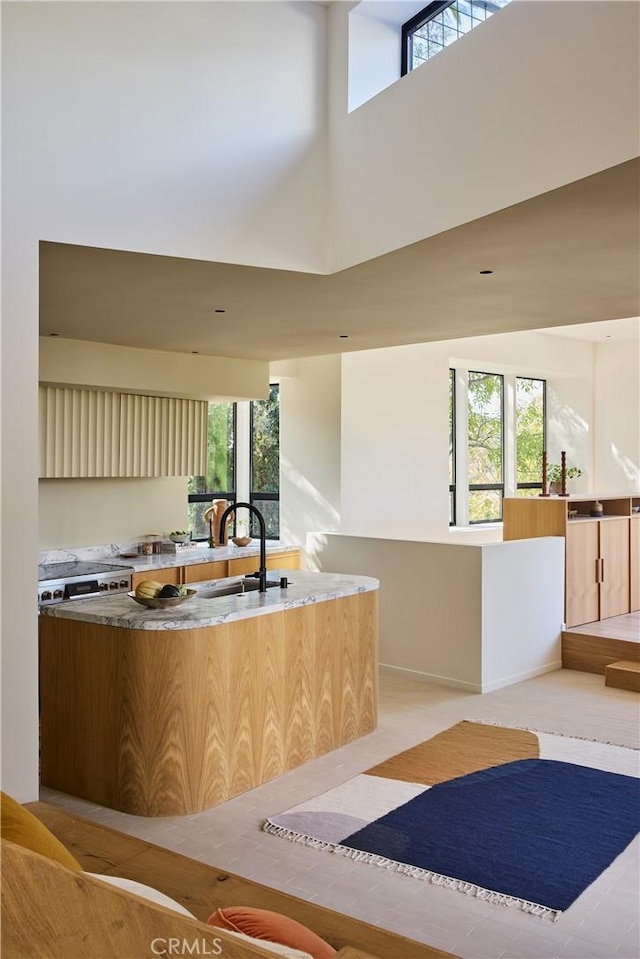 kitchen featuring sink, a high ceiling, and cream cabinets